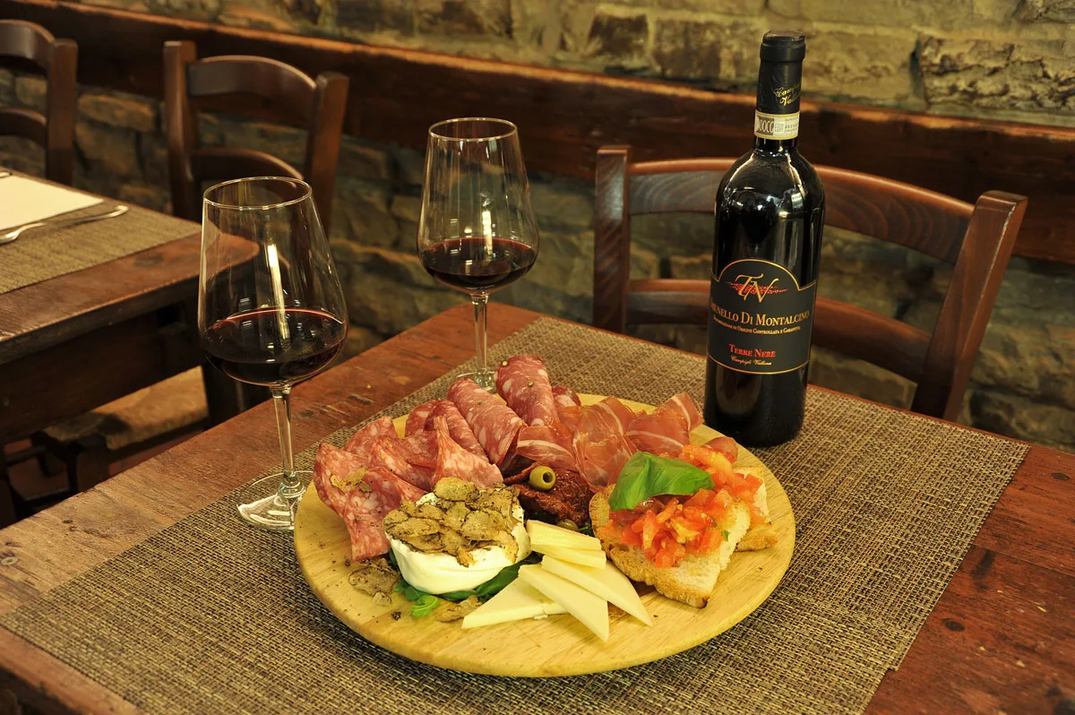 Salumi, formaggi e crostini con un rosso di Montalcino.